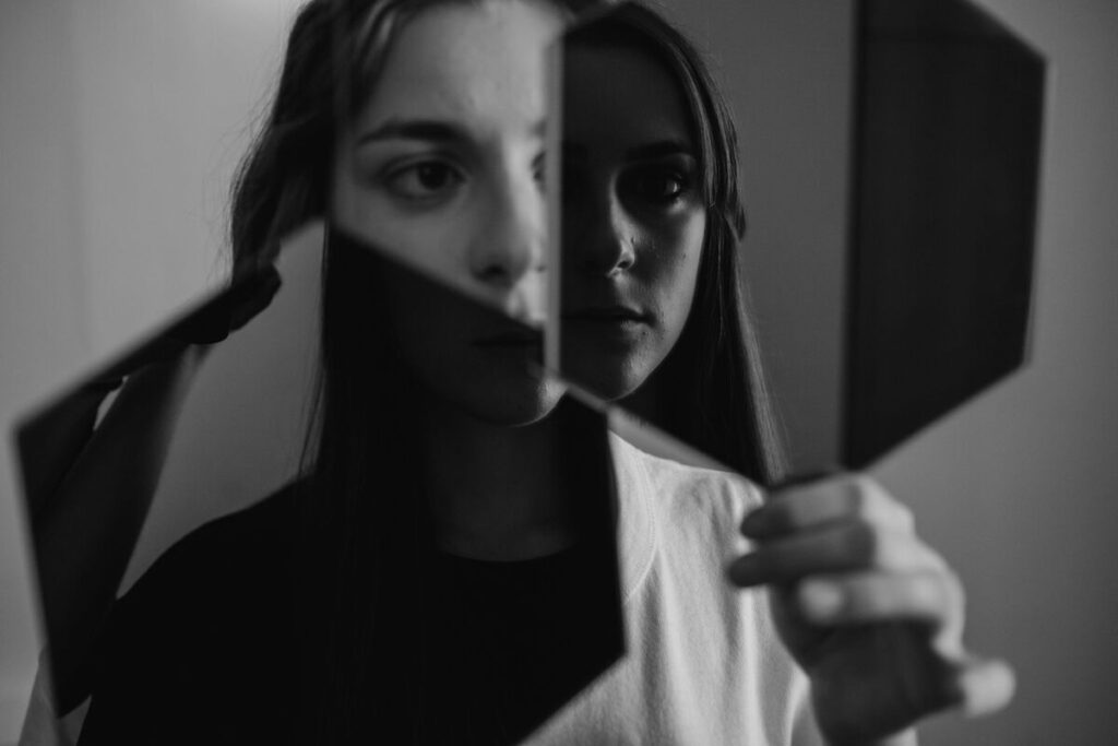Woman holding a mask showing hidden emotions
